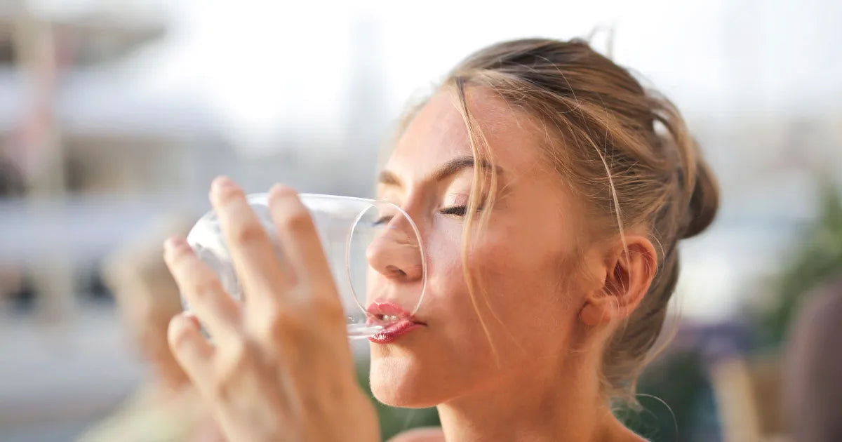 Femme détendue en terrasse l'été, boisson fraîche, ambiance vacances apaisée